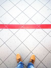 Low section of man standing on tiled floor