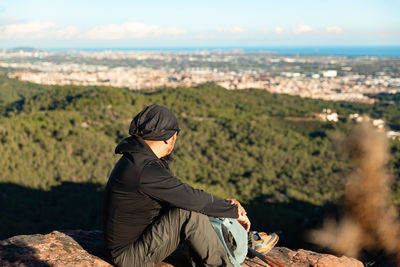 Middle-aged man contemplates the landscape of the garraf natural park, from the top of the mountain.