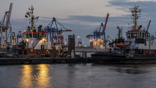 Tugboats in elbe river at illuminated harbor