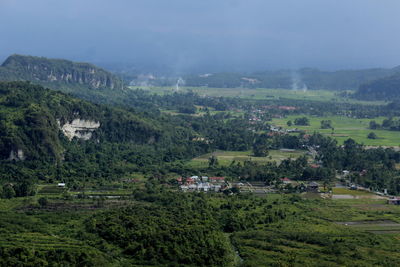 Scenic view of trees and buildings against sky