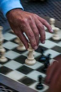 Cropped hand playing on chess board