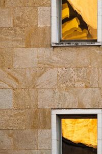 Low angle view of yellow window on wall of building