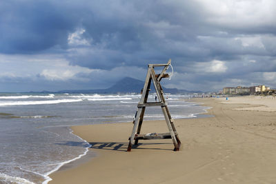 Lifeguard hut on beach against sky