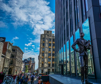 Statue of buildings in city against sky