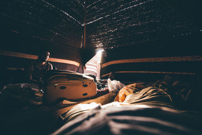 Man with luggage sitting in tent at night