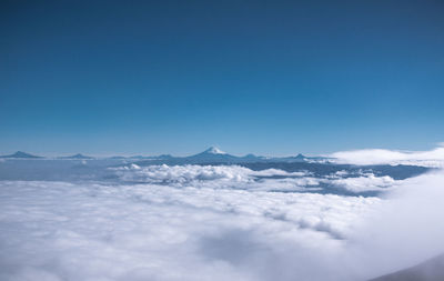 Scenic view of snowcapped mountains against blue sky