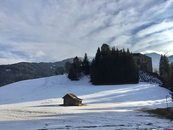 Built structure on snow covered field against sky