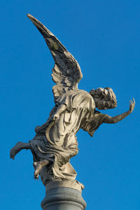 Low angle view of angel statue against clear blue sky