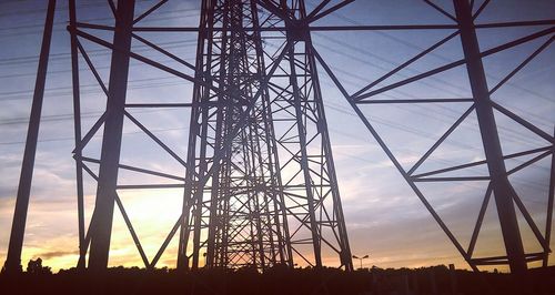 Silhouette electricity pylon against sky during sunset