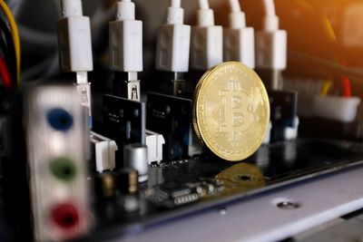 Close-up of bitcoin on circuit board at table