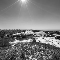 Scenic view of land against clear sky on sunny day