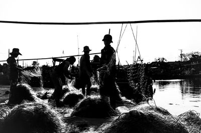 People standing by sea against clear sky