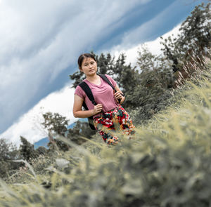 Full length of woman smiling on field against sky