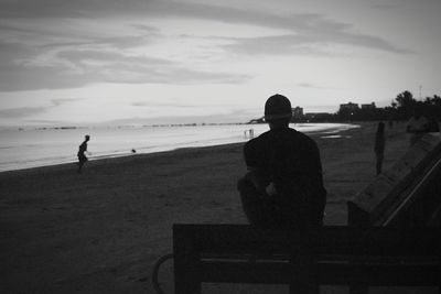 Silhouette man standing on beach against sky