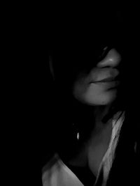 Close-up of woman against black background