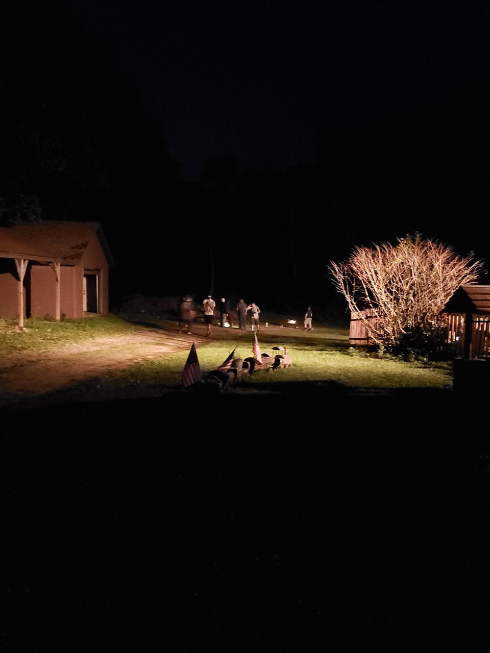 PEOPLE ON FIELD AGAINST ILLUMINATED BUILDINGS AT NIGHT