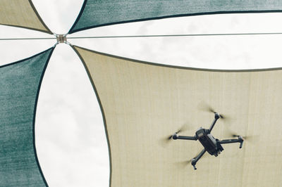 Low angle view of drone flying against ceiling