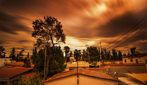 Silhouette of built structure against cloudy sky at sunset