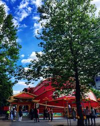 People at amusement park against sky