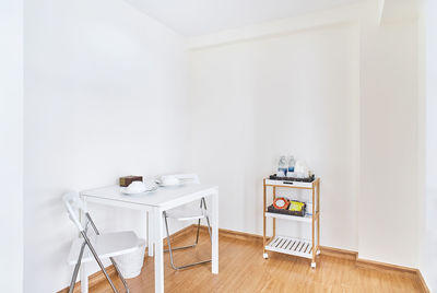 Empty chairs and table against wall at home