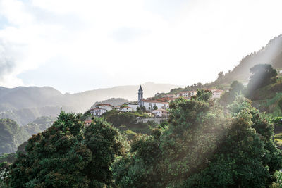 View of mountain village with church against sky