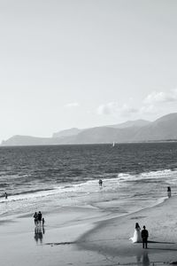 People at beach against sky