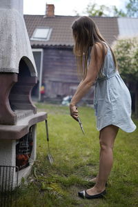 Woman standing in front of outdoor oven