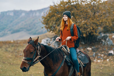 Young woman riding horse