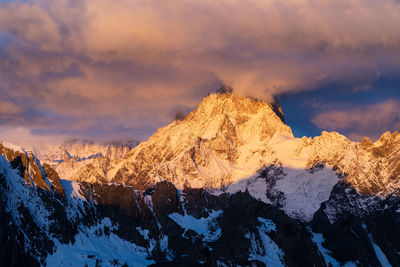 Scenic view of snowcapped mountains against sky during sunrise.