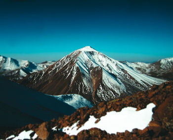 Scenic view of snowcapped mountain against blue sky