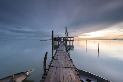 Pier over sea against sky during sunset