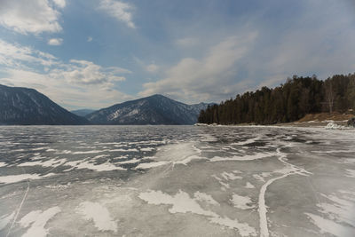 View of beautiful drawings on ice from cracks on the surface of lake teletskoye in winter, russia