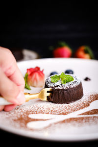 Cropped image of hand holding ice cream in plate