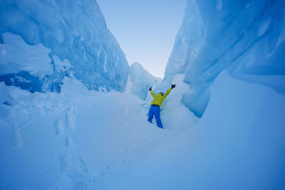 Rear view of woman standing on snow covered mountain