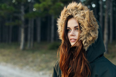 Young woman wearing fur hat while standing outdoors