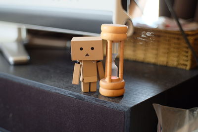 Close-up of hourglass with cardboard figurine on table