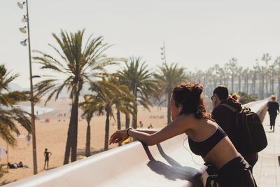 Rear view of couple at beach against sky