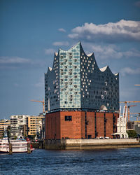 Buildings by sea against sky