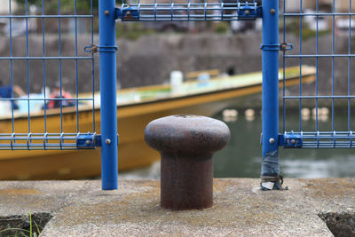 Close-up of metal railing by bench in park