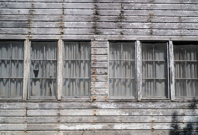 Windows of abandoned and weathered wood house