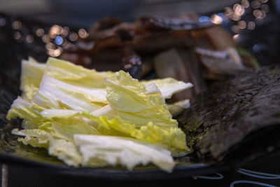 Close-up of napa cabbage, half-dried herring slices and dried seaweed in plate on table