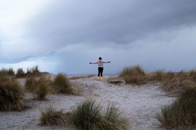 Man standing on field against sky