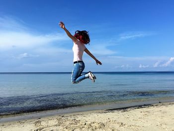 Man jumping in sea against sky