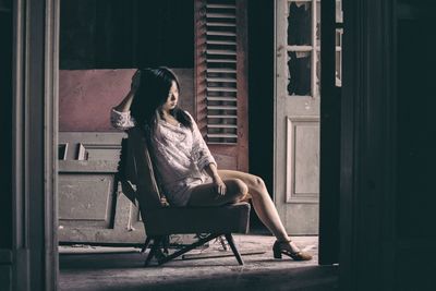 Woman sitting on chair in city