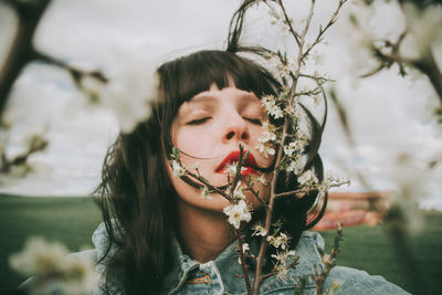 Portrait of young woman holding plant