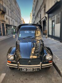 Car on street against buildings in city