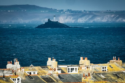 High angle view of buildings by sea against sky