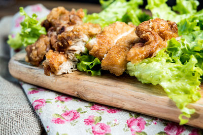 Close-up of chicken wings with lettuce on wooden board