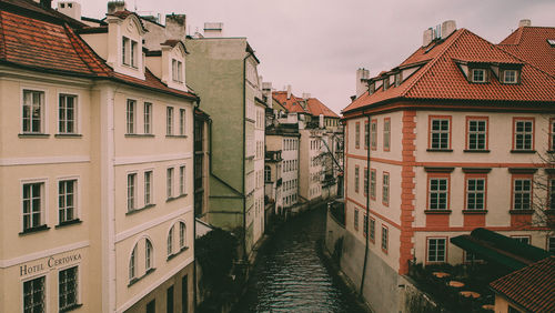 Canal amidst buildings in town against sky