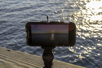 Close-up of coin-operated binoculars against sea